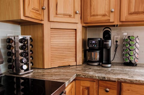 Fully stocked coffee station with Keurig, drip coffee maker and pot dual with a variety of pods and blends on granite counters — everything you need for your morning pick-me-up.