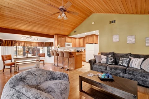Cozy mountain living room with a stone fireplace, comfy seating, and smart TV—perfect for relaxing evenings, movie nights, and warm cabin vibes after outdoor adventures.