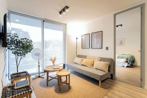 Bright and modern living space with cozy seating and natural light, perfect for relaxation and comfort.