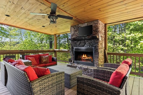 Outdoor living at its best—fireplace, TV, and a spacious dining area on the patio for a perfect evening.