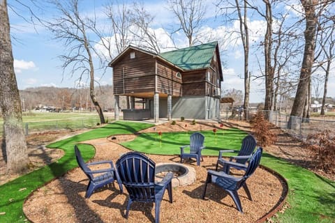 Fenced in back yard with a private putting green, fire pit, and hot tub.