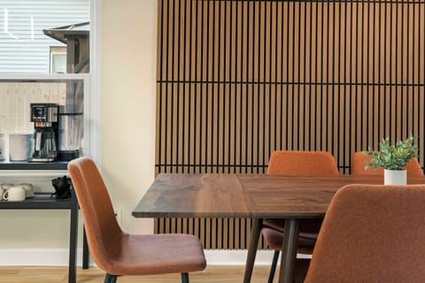 🍽️ Stylish Dining Meets Daily Comfort ☕ Gather around the modern dining table with cozy rust-colored chairs and enjoy easy access to the coffee bar just steps away—perfect for morning brews or evening chats.
