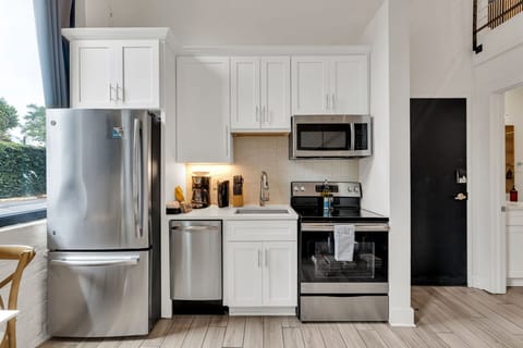 Fully equipped with stainless steel appliances, coffee station, and sleek cabinetry.