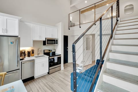 Sleek kitchen and staircase flow seamlessly into the bright main space.