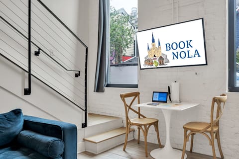 Wall-mounted smart TV and bistro-style desk setup with natural light.