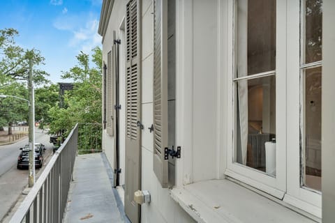 Charming balcony with classic shutters—perfect for a quiet moment overlooking a peaceful New Orleans street.