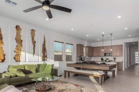 Relax in the spacious living room with plush seating, a smart TV, and a sleek pool table that doubles as a dining table, perfect for both game nights and enjoying a nice meal. 