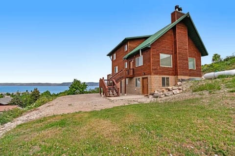 This striking wood and stone home sits perfectly on a hillside overlooking Bear Lake with direct views of the sparkling water.
