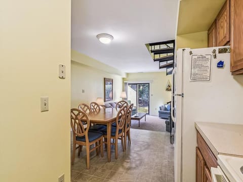This inviting dining area seamlessly connects to the living space, creating an ideal setup for gatherings while bathed in natural light from the sliding glass doors leading to the outside.