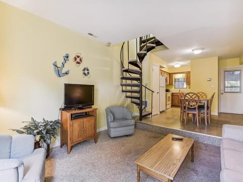 The spacious layout includes a relaxing seating area, elevated by charming nautical accents, making it a perfect spot to unwind after a day at the beach.