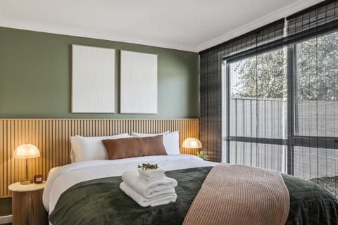 Spacious master bedroom with a plush king bed, quality linen, and soft natural light