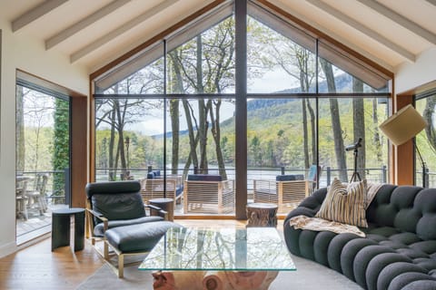 Massive windows in the living room reveal breathtaking views of the Shawangunks and private lake below.