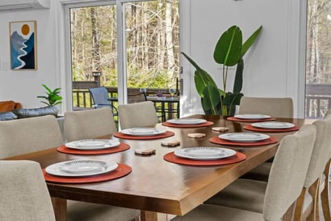 Open dining area with vaulted ceilings, beams, and cozy fireplace.