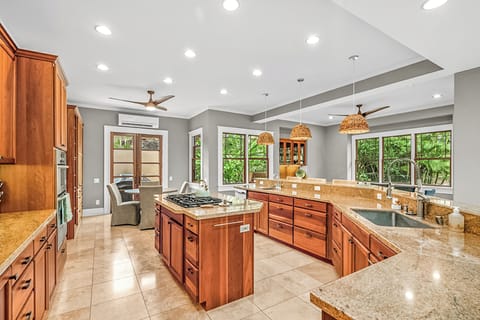 A fully equipped chef’s kitchen with sub-zero fridge, gas range, and breakfast bar makes every meal a pleasure