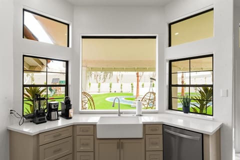 Enjoy backyard views while you cook in this bright, inviting kitchen with a sink that looks out over the serene outdoor space.