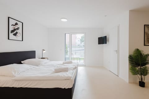 Sleeping area with double bed, TV, and terrace access.