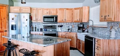 View of full kitchen. Bar seats 2