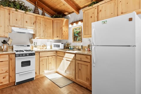 Compact kitchen w/ full-size appliances, wood cabinets & everything for home cooking.