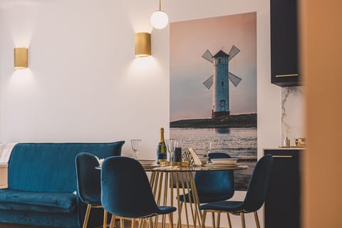 Stylish dining zone in a seaside apartment – a chic mix of blue suede and golden details creates a truly elegant setting.
