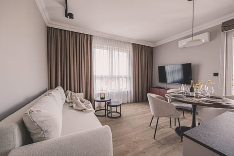 Spacious, modern living room with a comfy sofa and balcony access – apartment in Bydgoszcz’s upscale Industria estate.