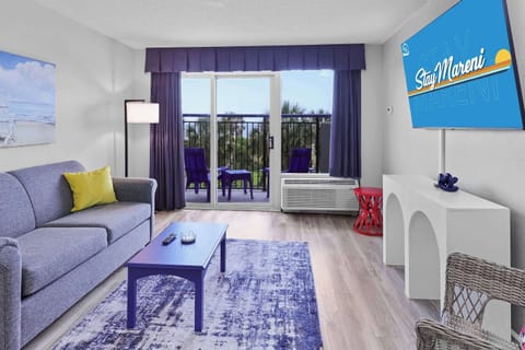 Breathe in ocean air from your private balcony, unwind in this bold, beach-chic living room, and catch golden sunsets on the smart TV—or in real life. Colorful, cozy, and just steps from the sand!
