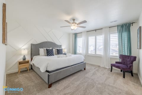 Spacious bedroom with upholstered bed and colorful accent chair