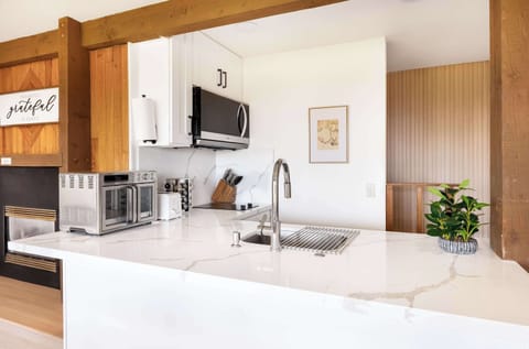 A bright kitchen with marble countertops, sleek appliances, and warm wooden accents.