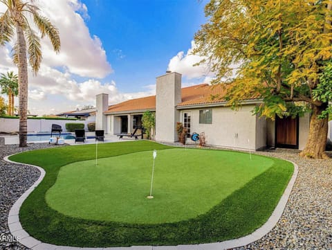 Practice your swing on the private putting green under desert skies
