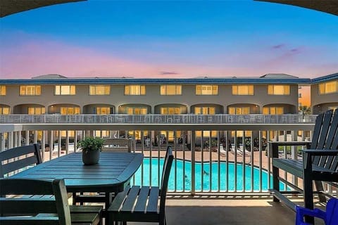 Relax on your private balcony overlooking the sparkling pool and evening glow.