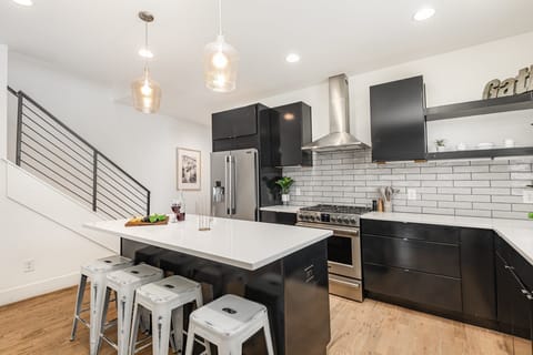 Unit 1: Fully Equipped Kitchen with stainless steal appliances, bar seating, and a dining area.