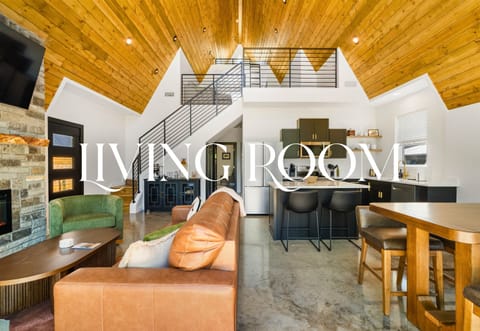 With oversized windows, cozy furniture, and wood-lined ceilings, the living room feels both expansive and grounded.