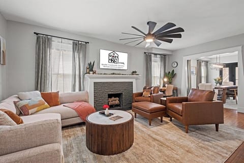 A bright, inviting living room featuring a modern sectional, cozy fireplace, Smart TV and warm mid-century accents—perfect for relaxing after exploring Hyde Park or nearby Gillham Park.