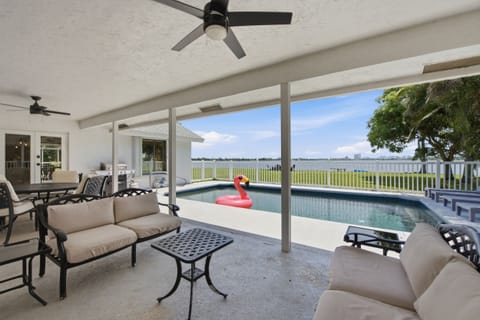 Covered lanai with lounge seating, a grill, and a private pool overlooking the water.