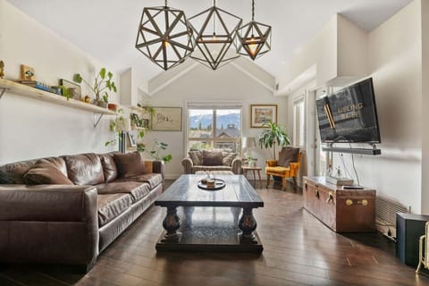 Living room with a Smart TV, cozy seating options, a record player and walkout access to the private balcony.
