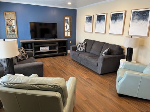 Comfortable living room with large screen TV and lots of natural light! 