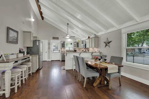 The dining table comfortably seats four, with additional seating available at the kitchen counter and the standalone bar.