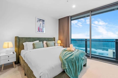 Spacious master bedroom with a modern king bed and stunning ocean views facing east.