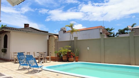 Piscina aberta todo o ano e área externa com móveis e chuveiro.
