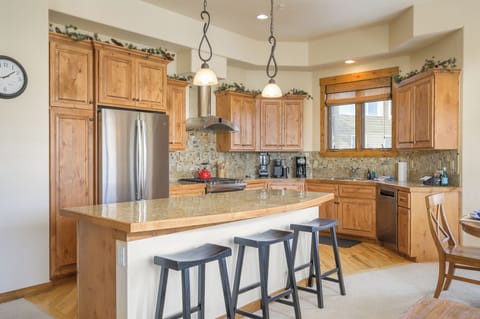 - Kitchen island with seating for three adds space for dining and conversation   - Granite countertops and pendant lighting highlight this warm rustic design   - Fully equipped kitchen blends style function and comfort for group meals