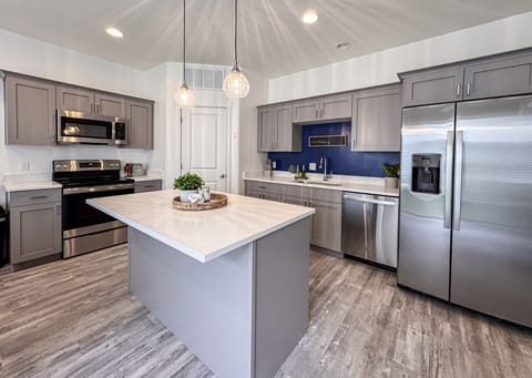 Sleek modern kitchen with quartz countertops, stainless steel appliances, and cozy pendant lighting accents.