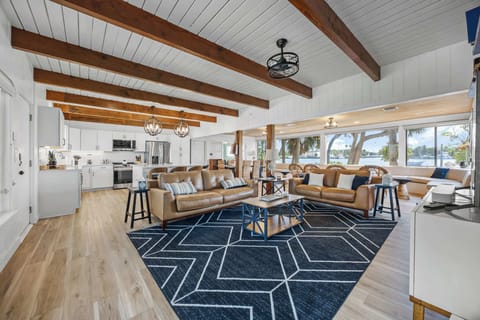 Open living area with exposed wood beams and waterfront views through large windows