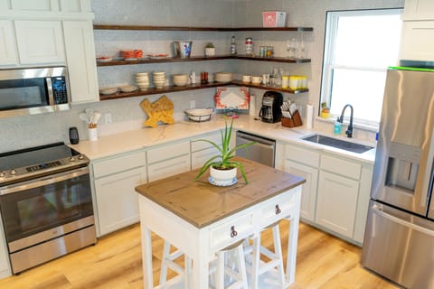 Open concept, fully equipped kitchen with stainless steel appliances. Island doubles as a dining table with seating for 4 guests.