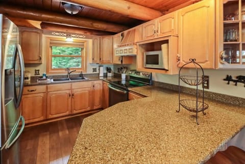 Prepare meals with ease in this charming Northwoods kitchen, featuring full-size stainless steel appliances, ample counter space, and rustic wood cabinetry. Whether you`re cooking up the day’s catch from Little Saint Germain Lake.