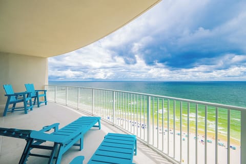 Relax in vibrant blue chairs on the spacious balcony, enjoying sweeping views of the tranquil waters below