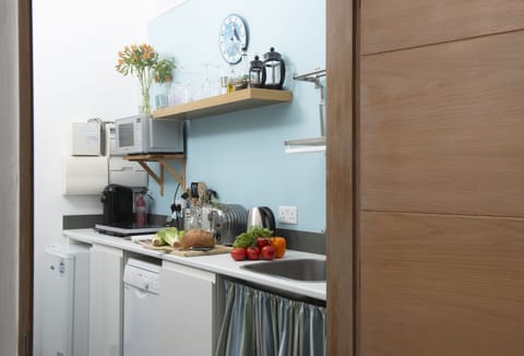 The Perch at Rockside, Polzeath: Kitchen with electric hot plates, microwave, fridge, slimline dishwasher, and Nespresso Vertuo coffee machine