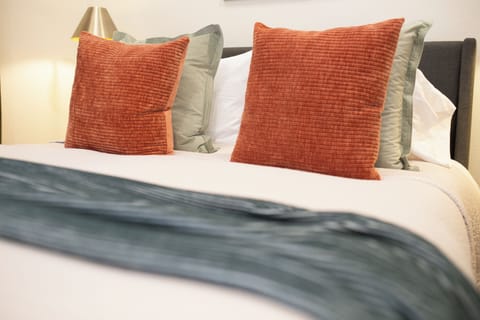 Comfy pillows and a neatly layered bed for ultimate relaxation.