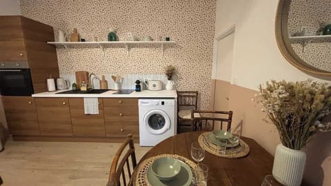 Cuisine ouverte sur le salon, équipée avec four, plaques de cuisson, machine à laver, lave vaisselle, bouilloire, grille-pain, machine à café, micro-ondes et petit réfrigérateur.