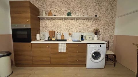 Cuisine ouverte sur le salon, équipée avec four, plaques de cuisson, machine à laver, lave vaisselle, grille pain, bouilloire, machine à café, micro-ondes et petit réfrigérateur.