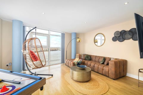 Stylish living area featuring a unique hanging chair and stunning views of the River Thames—the perfect place to relax and unwind