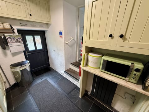 Steps down to kitchen, microwave and storage cupboards.
